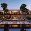 Modern tropical resort with an open-air lounge, palm trees, and poolside seating at dusk.