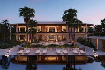 Modern tropical resort with an open-air lounge, palm trees, and poolside seating at dusk.