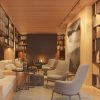 Cozy modern library lounge with built‑in wooden shelves, warm lighting, and a central fireplace flanked by beige seating.