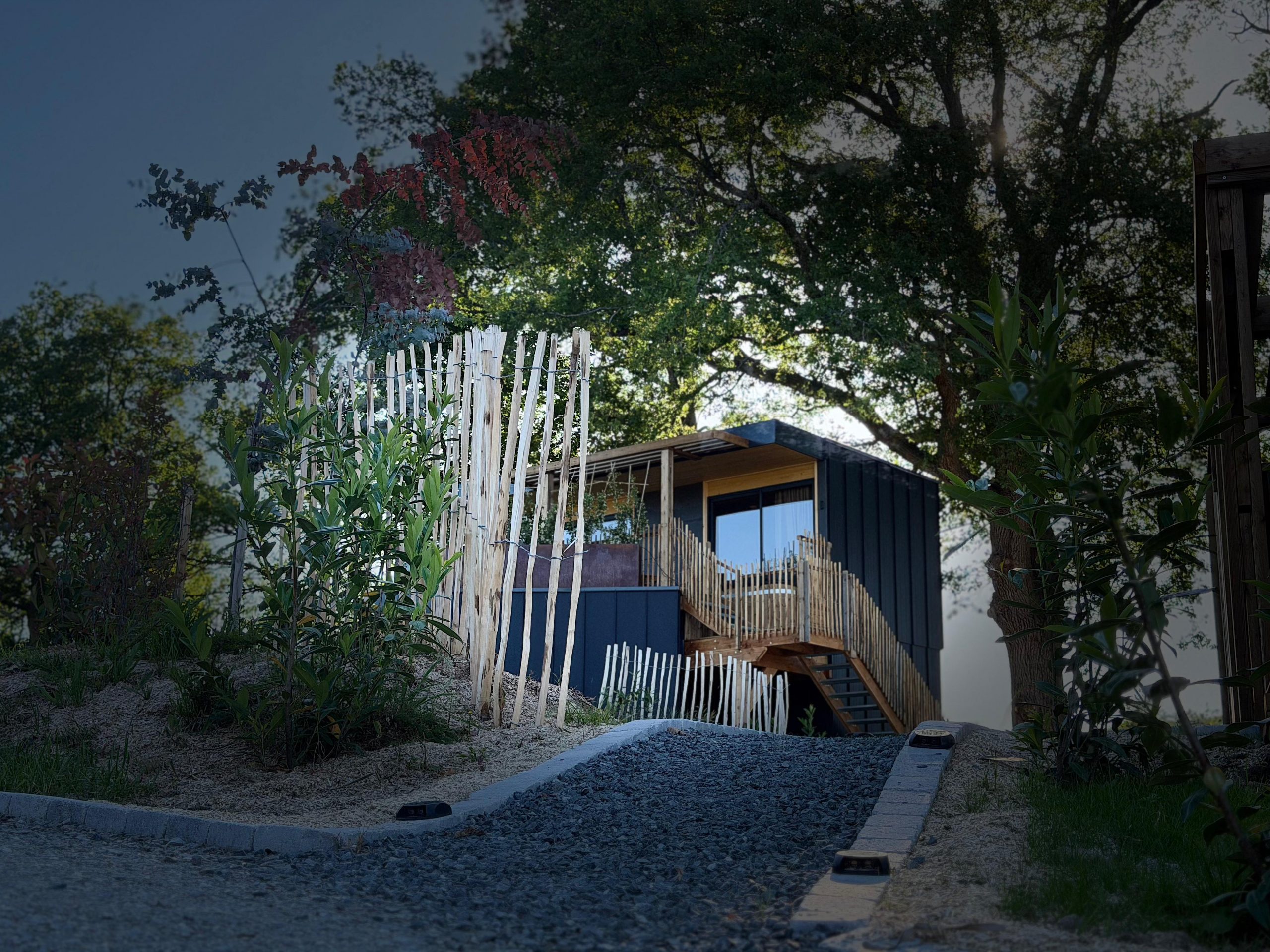 Pépite Lodge Spa façade nuit bois sombre éclairage doux