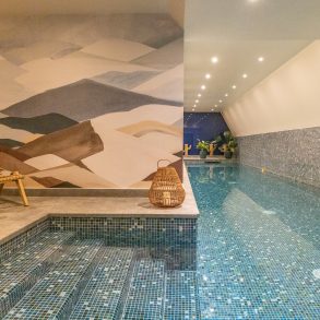 Piscine intérieure du spa Parister, lumière naturelle, mosaïque bleue