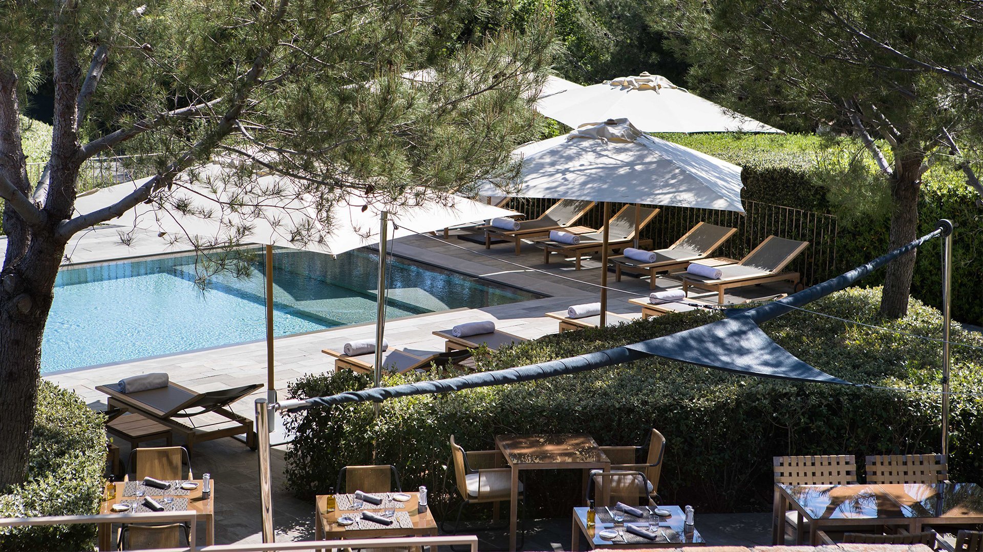 Vue aérienne piscine La Réserve Ramatuelle avec pins parasols