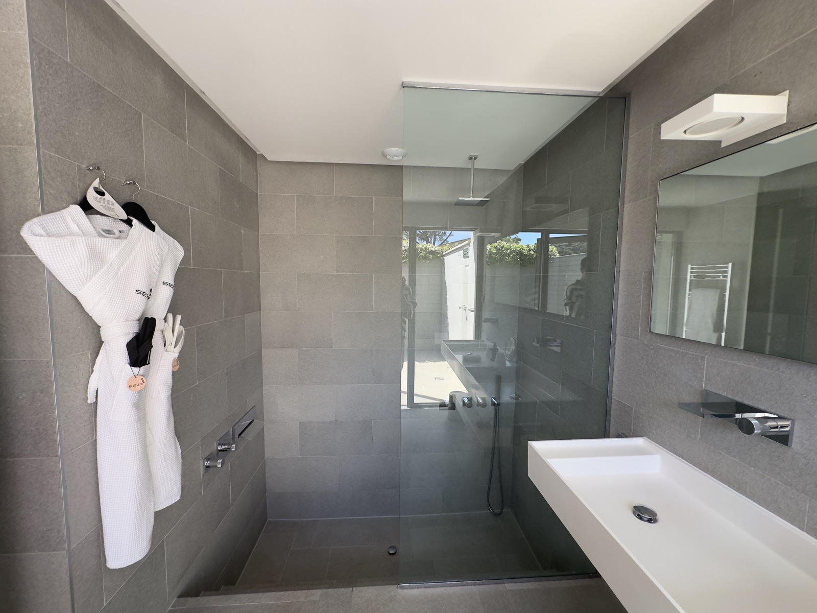 Salle de bain avec douche italienne et peignoirs Sezz