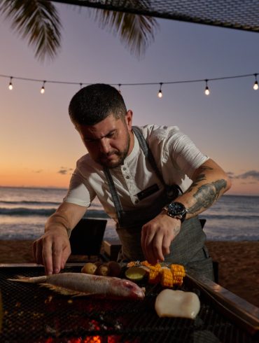 Chef Patricio Mardones prépare un poisson sur grill au coucher du soleil, plage du Sublime Samana Hotel & Residences