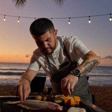 Chef Patricio Mardones prépare un poisson sur grill au coucher du soleil, plage du Sublime Samana Hotel & Residences