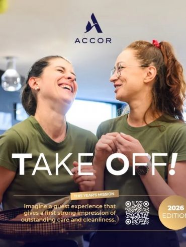 Two smiling women in green shirts share a moment in a modern cafe; ACCOR logo above and 'TAKE OFF!' headline overlaid.
