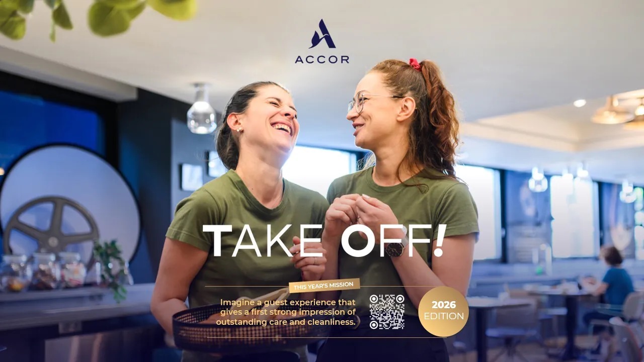 Two smiling women in green shirts share a moment in a modern cafe; ACCOR logo above and 'TAKE OFF!' headline overlaid.