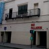 White brick building with a black metal balcony above the entrance; red letters spell 'BUS PALLADIUM' and a 'Concert Restaurant Bar Club' sign on the façade.