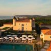 Un palace méditerranéen avec piscine au soleil couchant, sur fond de canicule