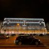 Le 103-111 Champs-Élysées habillé d’une malle Louis Vuitton géante illuminée, la nuit, sur l’avenue.