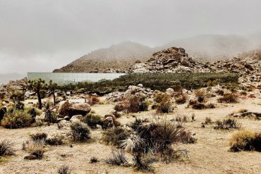 Vue extérieure de The Invisible House à Joshua Tree, façade en verre réfléchissant miroir dans le désert californien