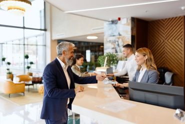 Une réceptionniste sert un client dans le hall d'un hôtel de luxe en Espagne