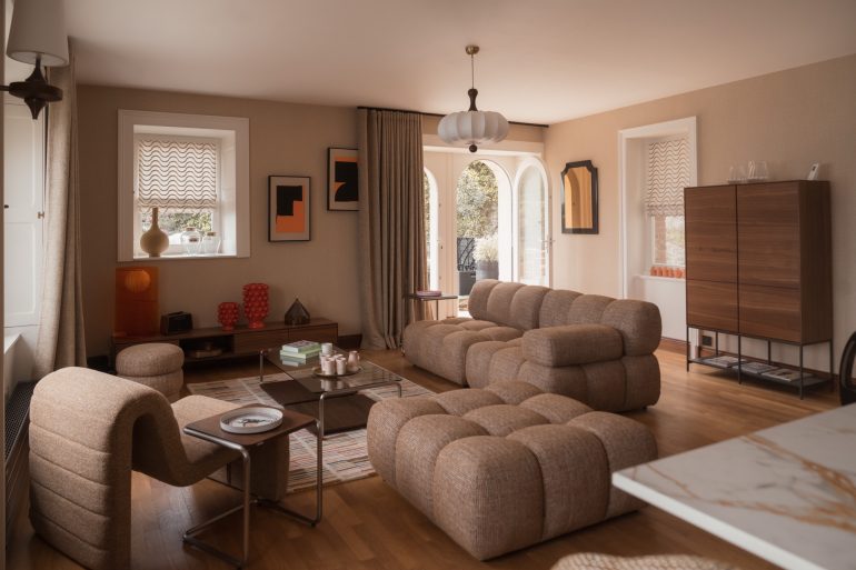 Le salon de la Villa Isis à Dinard, canapé bouclé et esprit seventies face à la mer
