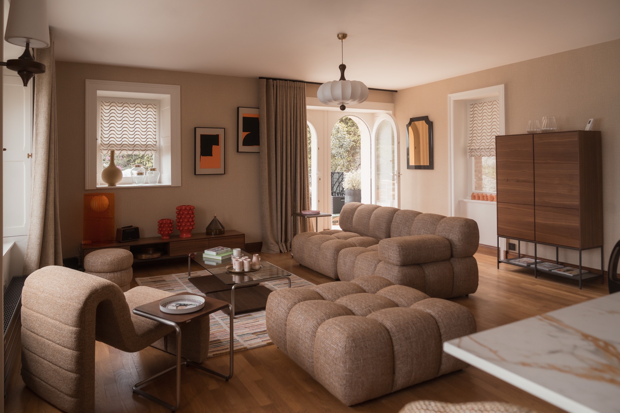 Le salon de la Villa Isis à Dinard, canapé bouclé et esprit seventies face à la mer