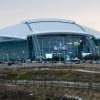 Modern stadium with glass facade and a snow-covered curved roof; NBA All-Star 2010 logo on the front.