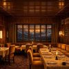 Cozy alpine restaurant with wooden walls, candlelit tables, and a window showing snow-capped mountains at sunset.