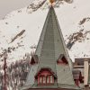 La tour emblématique du Badrutt’s Palace à Saint-Moritz devant les sommets enneigés de l’Engadine
