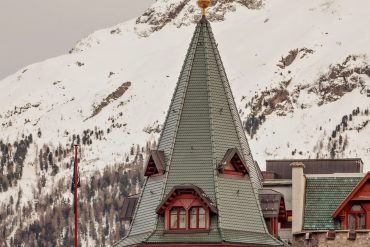 La tour emblématique du Badrutt’s Palace à Saint-Moritz devant les sommets enneigés de l’Engadine