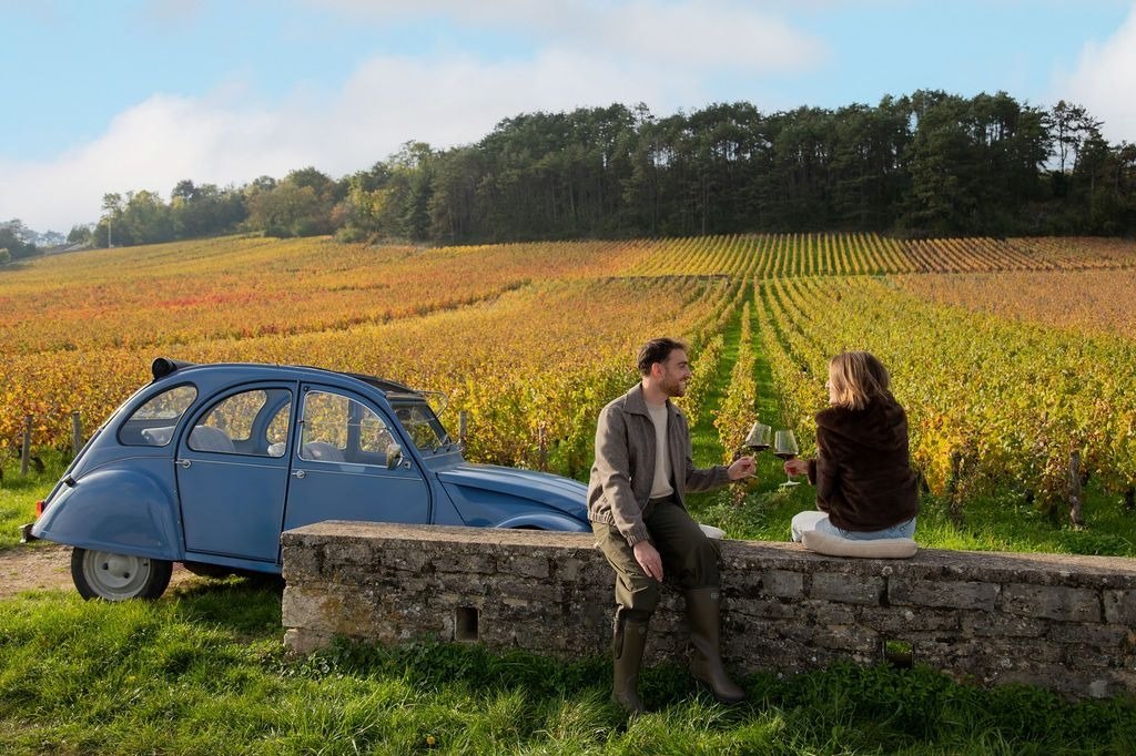 Une Citroën 2CV garée au bord des vignes, lors d'une balade proposée par le Château La Commaraine