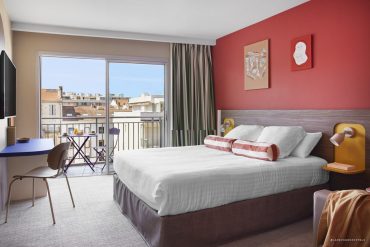 Chambre colorée de l'Hôtel Abrial avec balcon sur les toits de Cannes, groupe Soniho