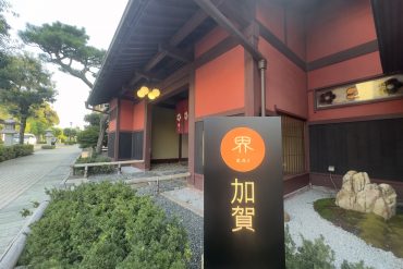 La façade rouge bengara du ryokan Kai Kaga et son enseigne KAI 加賀, à Yamashiro Onsen