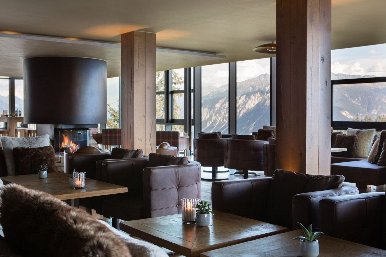 Le salon du Crans Ambassador, sa cheminée et ses baies ouvertes sur la vallée