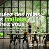 Banner promoting Airbnb Miles: large French headline over a glass-walled tropical dining room; man stands at a long table amid green accents on the sides.