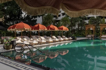 La piscine rénovée de l'Anantara Siam Bangkok, transats et parasols orange