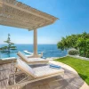 Pergola et piscine a debordement du Borgo Santandrea sur la cote amalfitaine, transats face a la Mediterranee