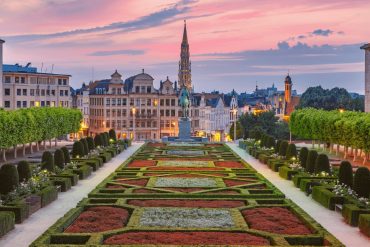 Vue du Mont des Arts à Bruxelles au crépuscule, avec la flèche de l’Hôtel de Ville, siège des institutions européennes qui légifèrent sur les locations de courte durée