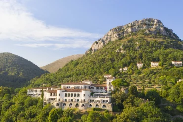Le Château Saint-Martin & Spa à Vence vu du ciel, sa façade ocre posée sur une colline boisée face au Baou des Blancs, sur la Côte d'Azur