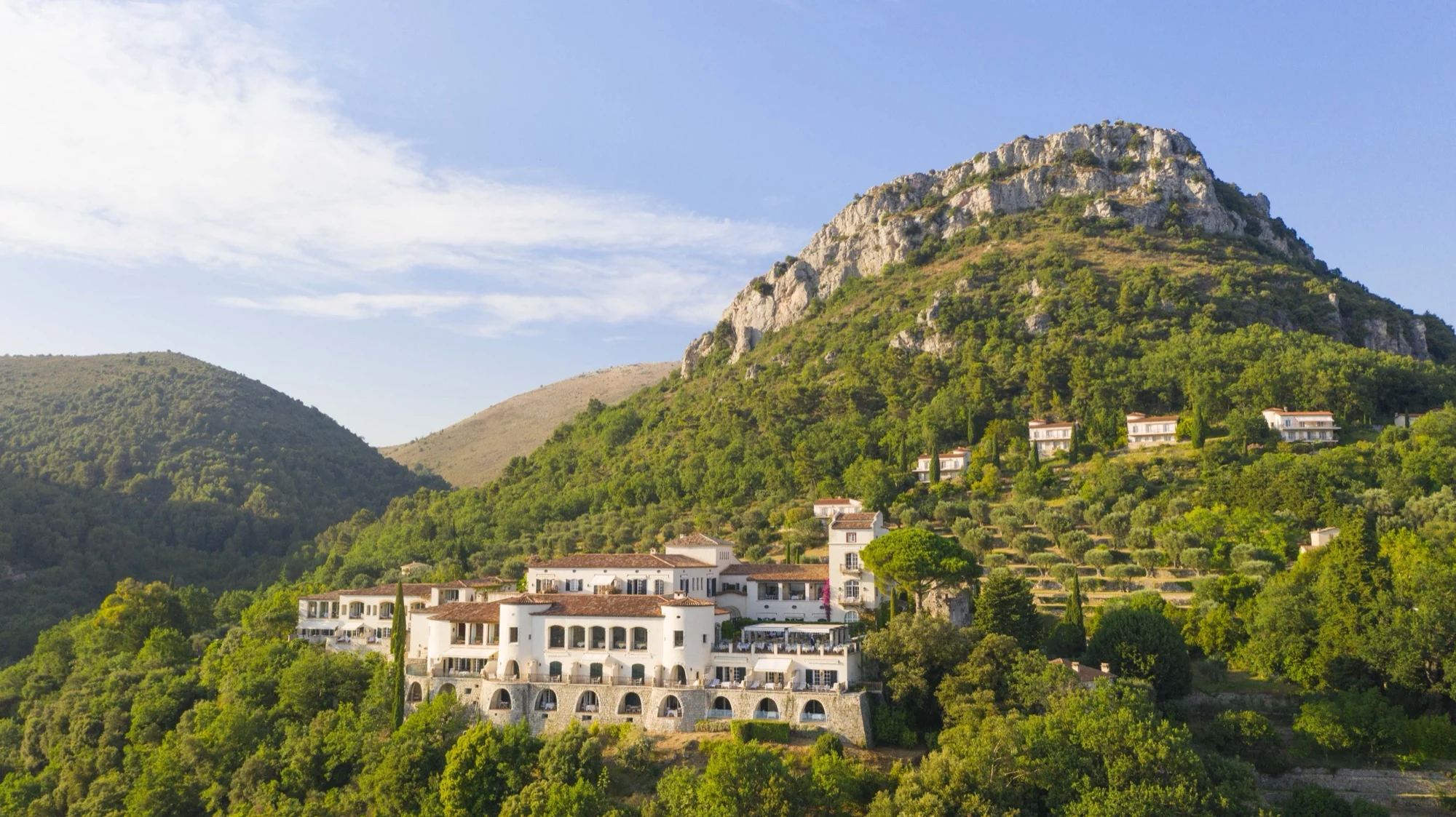 Le Château Saint-Martin & Spa à Vence vu du ciel, sa façade ocre posée sur une colline boisée face au Baou des Blancs, sur la Côte d'Azur
