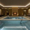 Les deux bassins carrelés du Corinthia Spa Rome, sous les voûtes de l'ancienne salle des coffres de la Banca d'Italia, cheminée et transats