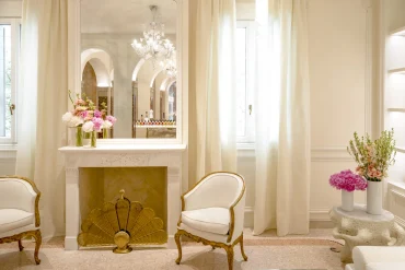 Salon du Dior Spa de l'hôtel Cipriani à Venise, fauteuils crème, cheminée en marbre et lustre en verre de Murano, décor signé Peter Marino