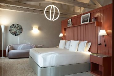 Chambre de l’hôtel Elizabeth Unique Venice à Cannaregio, boiseries terracotta et suspension lumineuse dessinées par Cristina Celestino