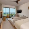 Chambre Ocean Front King du Grand Hyatt Cancun Beach Resort, lit face aux baies vitrees ouvertes sur la mer des Caraibes et la terrasse privee