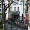 Façade de l'Hôtel du Nord, 102 quai de Jemmapes à Paris, terrasse au store rouge et vélos sur le canal Saint-Martin