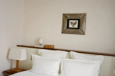 Une chambre de l’hôtel Massé, à Pigalle, avec son lit blanc et son cadre ancien