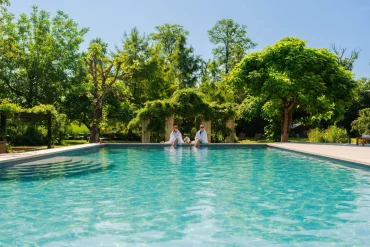 La piscine extérieure en eau naturelle du Château de Germigney, bordée d'arbres, à Port-Lesney dans le Jura