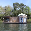 Un lodge flottant de Brindos, Lac & Château, avec son bain nordique en bois sur la terrasse, sur le lac de Brindos à Anglet