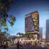 Rendu de nuit du NoMad Singapore, tour à la façade végétalisée en cascade sur Orchard Road, terrasse animée au pied