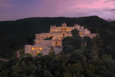 The Oberoi Rajgarh Palace, palais Bundela éclairé au crépuscule sur une colline boisée près de Khajuraho