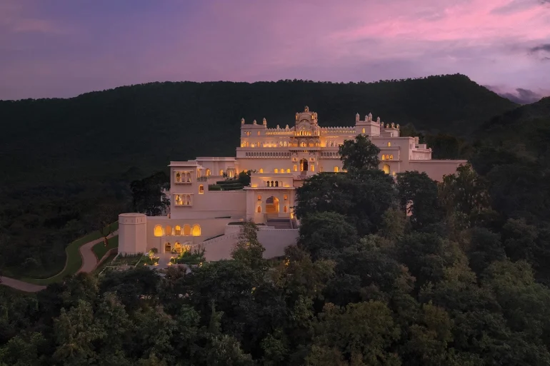 The Oberoi Rajgarh Palace, palais Bundela éclairé au crépuscule sur une colline boisée près de Khajuraho