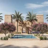 Rendu de l'entrée de The Oberoi Sukoonvilas à Wadi Safar, façade najdie en pisé à tours crénelées, bassin et palmiers