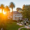 Le manoir du Palm House Boutique Hotel & Spa au Cap au coucher du soleil, pelouse et terrasses de jardin sous les palmiers de Wynberg