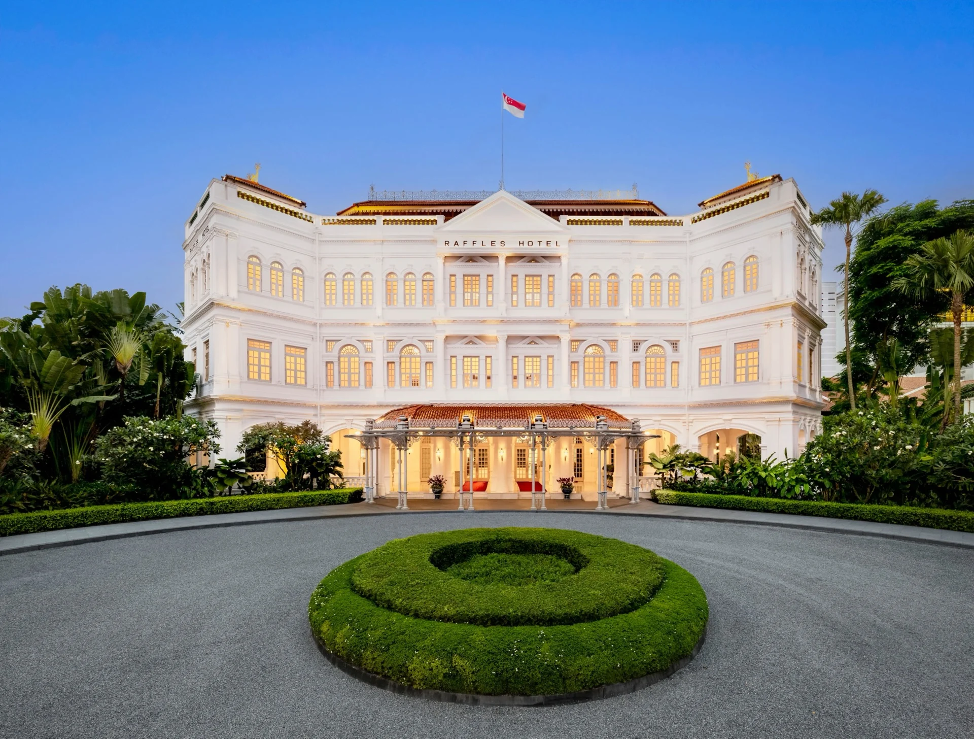 Façade du bâtiment principal et rond-point d'entrée, ciel bleu
