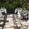 Tables nappées de blanc de Maison Roland, le bistrot du jardin du Shangri-La Paris, sous les arbres de l'avenue d'Iéna