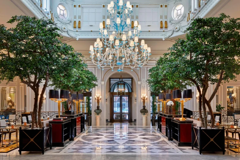 Le grand hall du St. Regis Rome avec son lustre de Murano et ses arbres