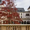 La cour intérieure de l'hôtel The Florentin à Francfort, arbre rouge d'automne devant la villa de 1901 et ses arcades