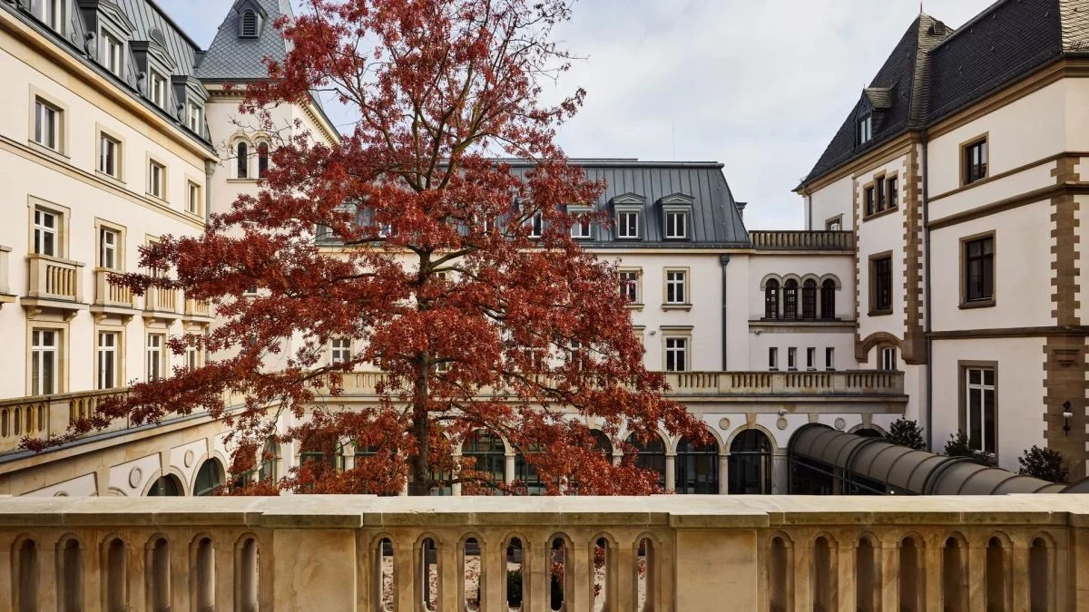 La cour intérieure de l'hôtel The Florentin à Francfort, arbre rouge d'automne devant la villa de 1901 et ses arcades